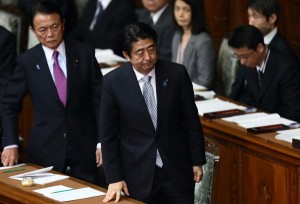 Taro Aso, Japan's deputy prime minister and finance minister, left, and Shinzo Abe, Japan's prime minister, stand as they leave an ordinary session at the lower house of parliament in Tokyo, Japan, on Monday, Jan. 26, 2015. Abe may leave out key descriptions of Japan's World War II conduct in a statement to be issued in August on the 70th anniversary of its defeat, he said in a television interview Sunday. Photographer: Tomohiro Ohsumi/Bloomberg via Getty Images